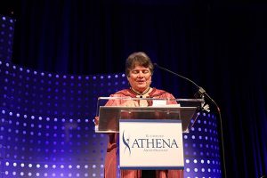 Dr. Gilbert at the podium receiving the 2019 Athena award.